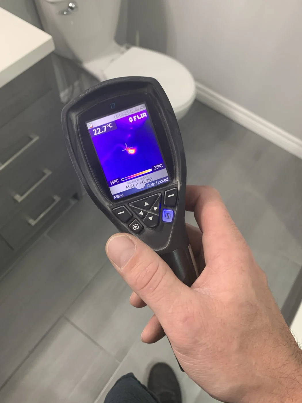 Thermal camera showing a distinct hot spot above an intact tiled bathroom floor