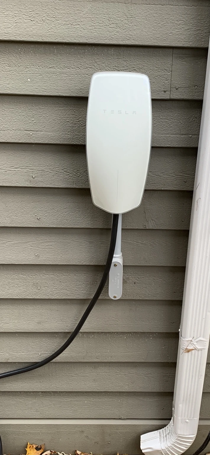 Completed outdoor Tesla Wall Connector installation on house siding