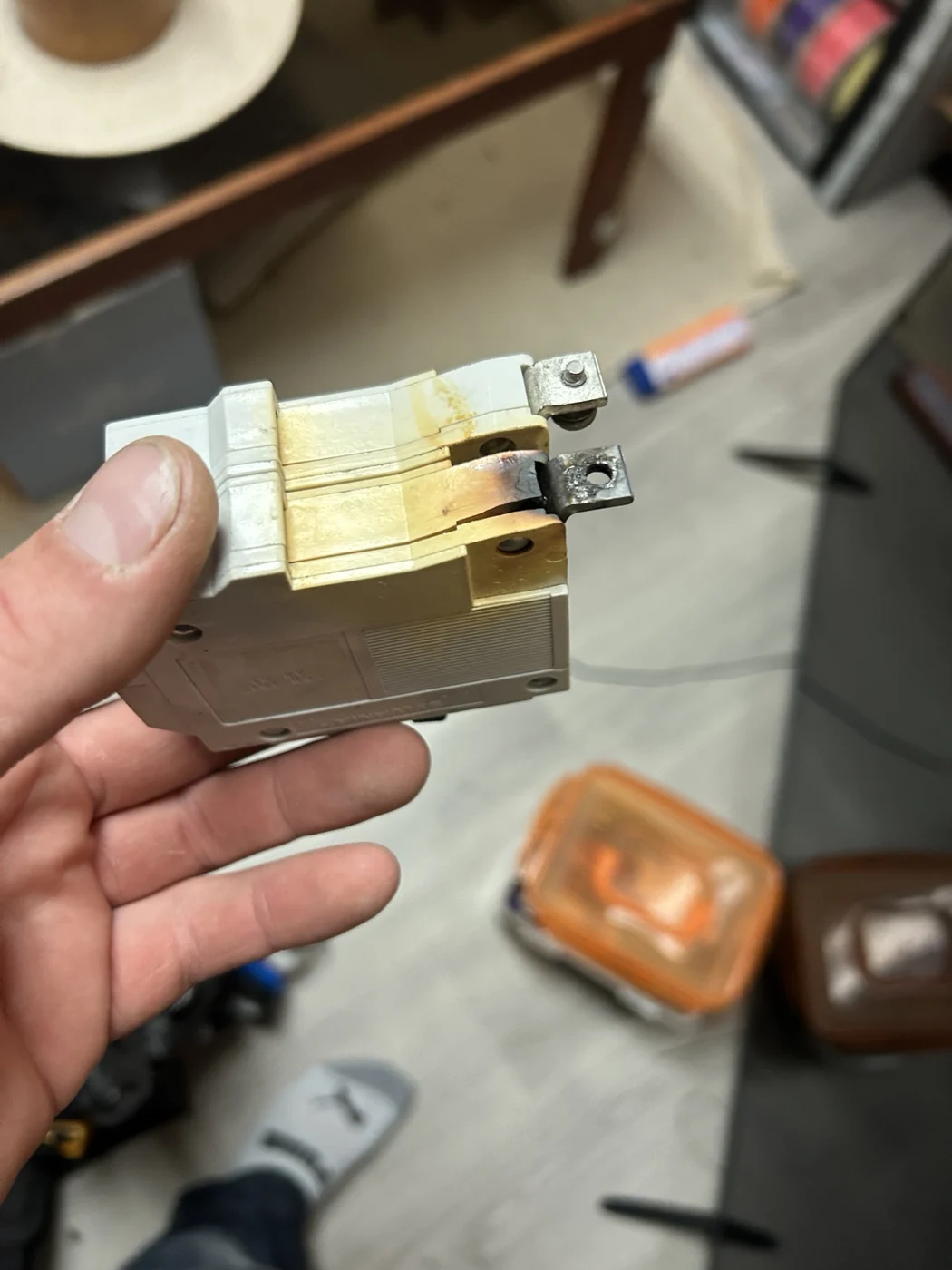 Removed circuit breaker showing discoloration and damage at its rear connection