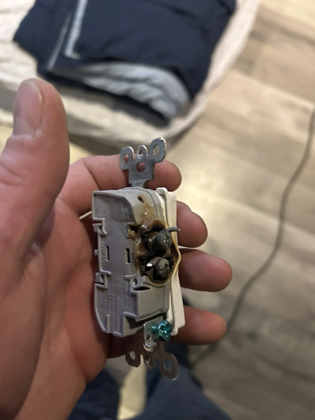 Removed receptacle showing burned and melted material around its side terminals